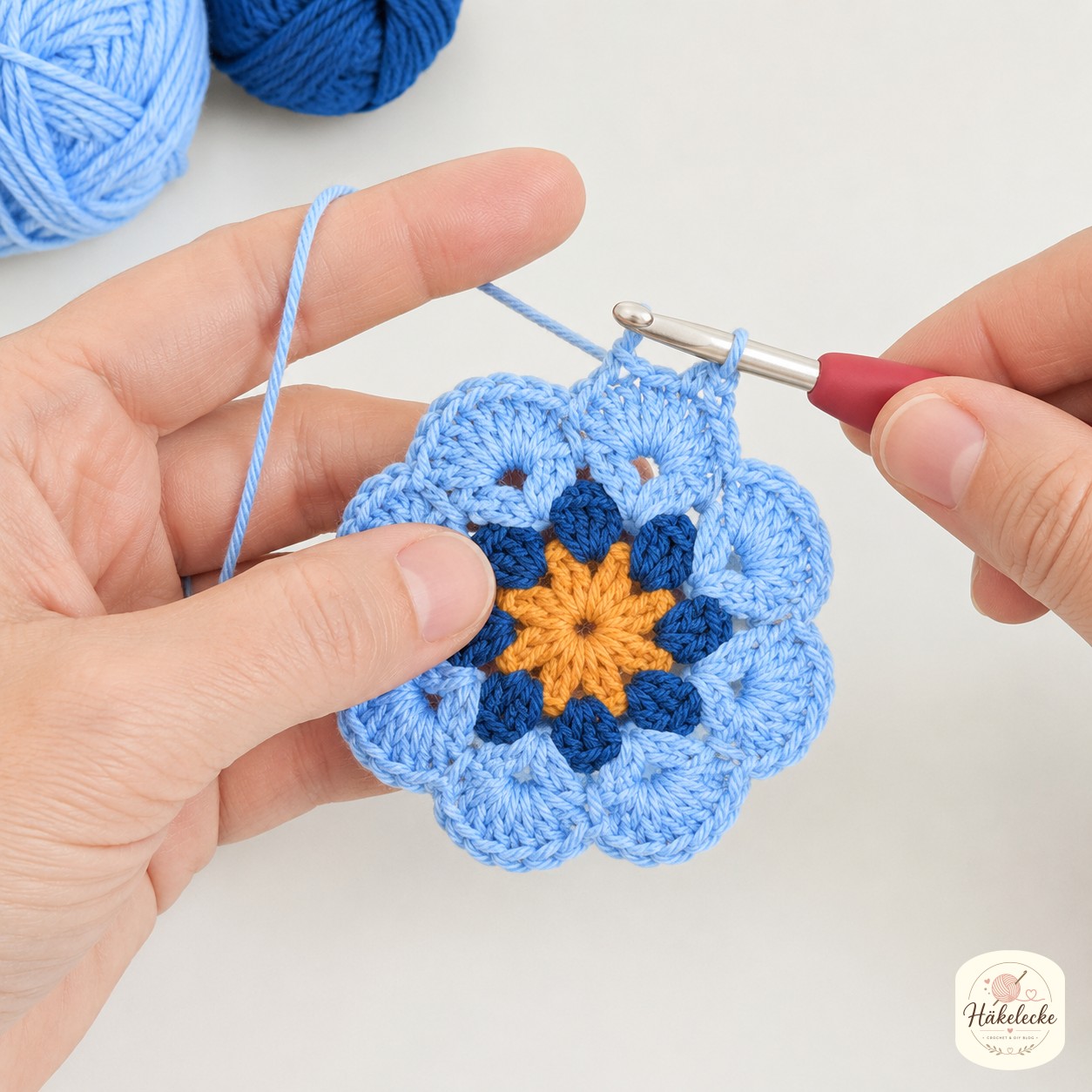 Runde drei in Hellblau formt die zweite Blütenschicht des African Flower Granny Squares
