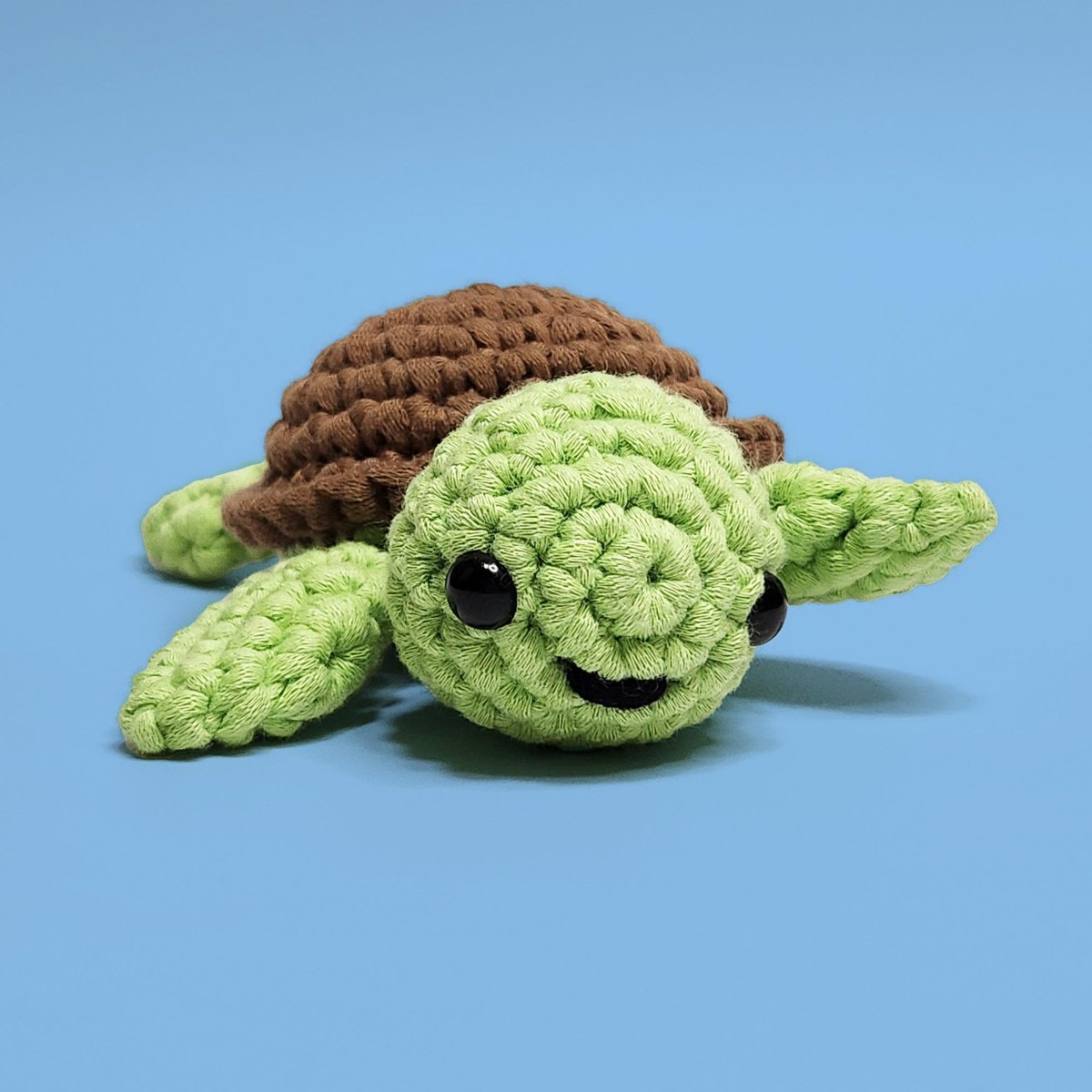 Grüne Amigurumi-Schildkröte mit braunem gehäkeltem Panzer