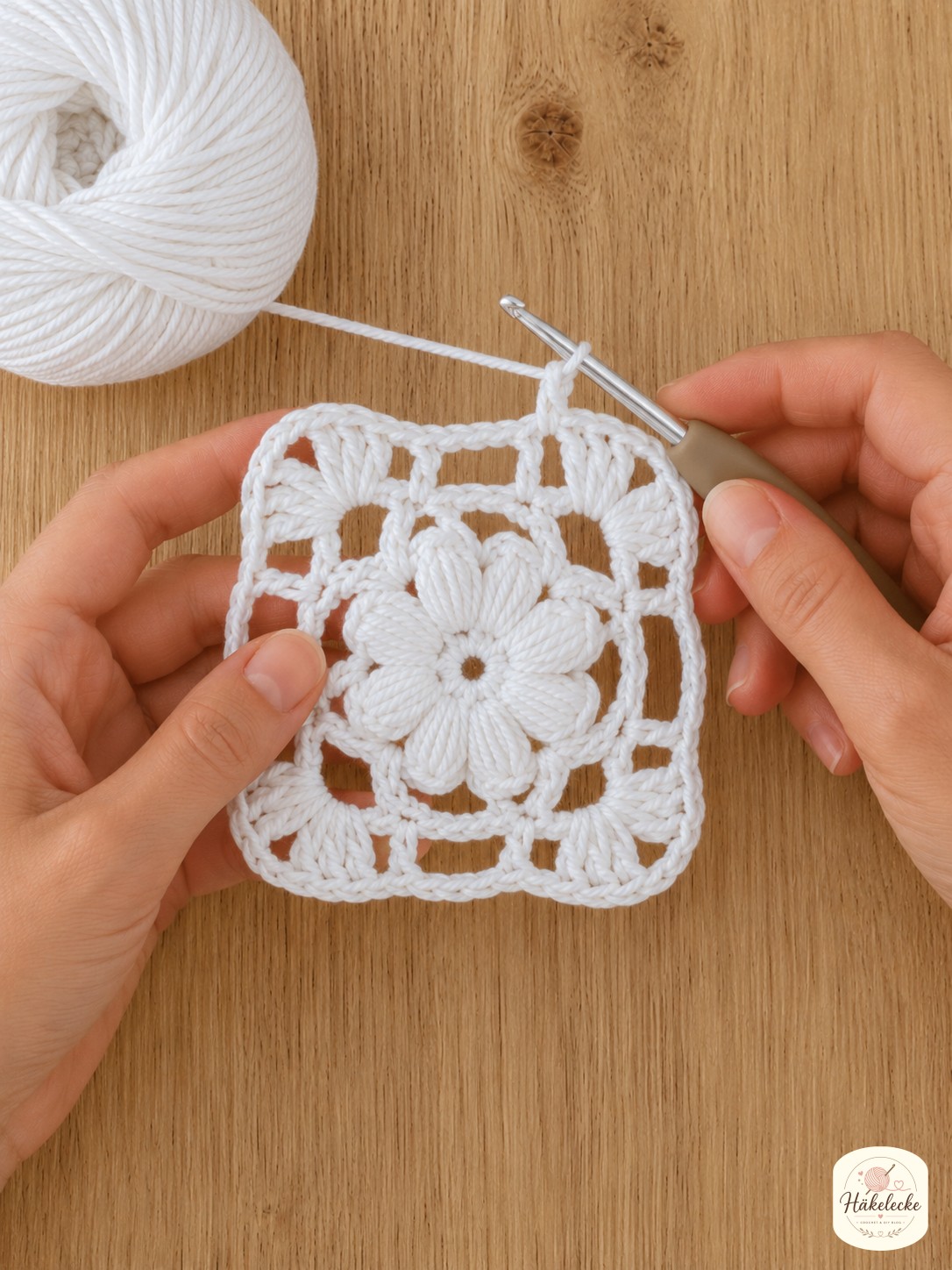 Maschenraum und Muschelecken zeigen die Quadratform beim Blumen Granny Square weiß häkeln.