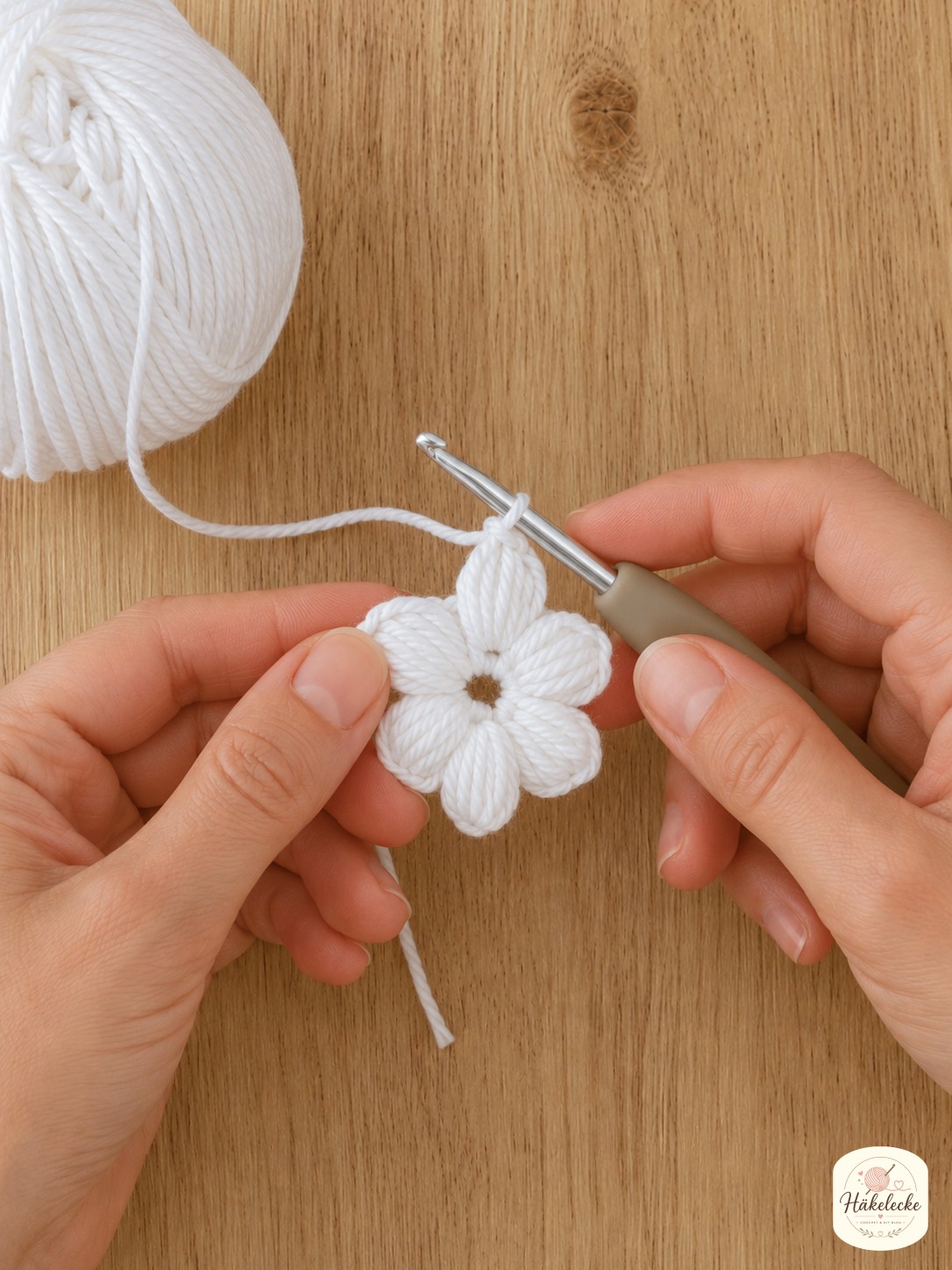 Sechs Büschelmaschen bilden die erhabene Blütenmitte beim Blumen Granny Square weiß häkeln.