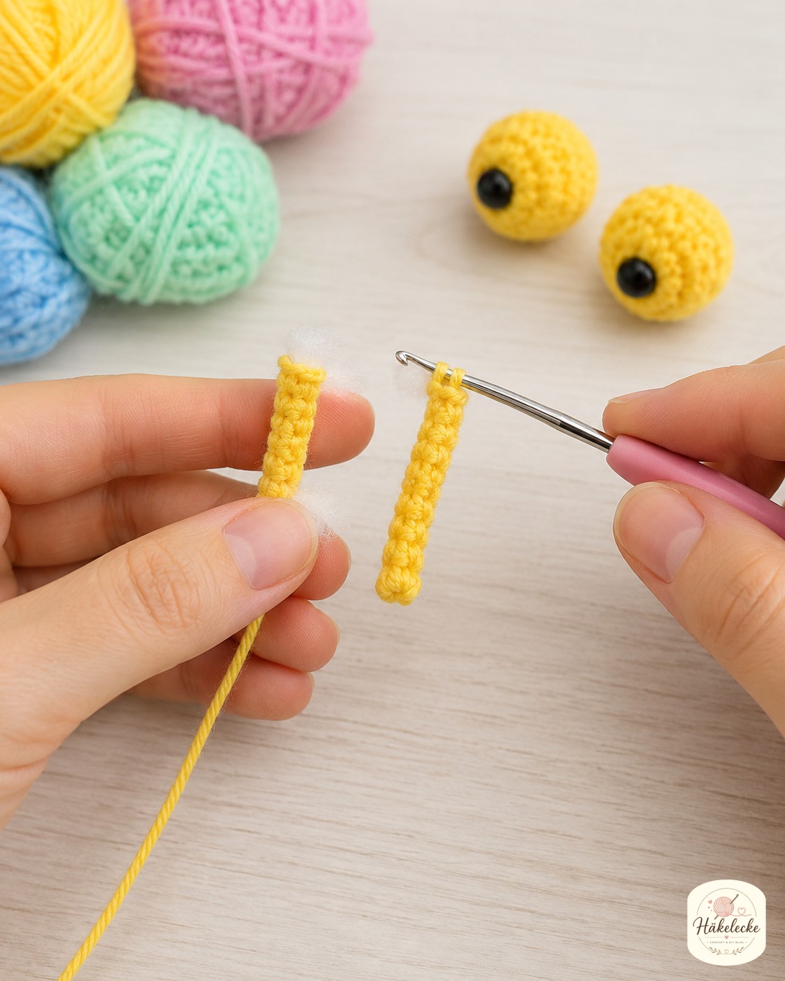 Zwei gelbe Fühlerstiele und runde Augäpfel entstehen für die bunte Amigurumi-Schnecke.