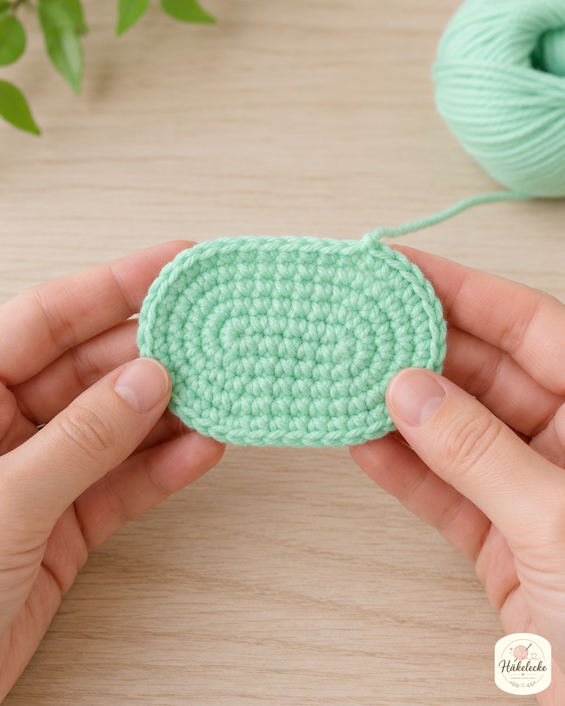 Die mintgrüne ovale Fußsohle der Amigurumi-Schnecke wächst in Spiralrunden aus festen Maschen.