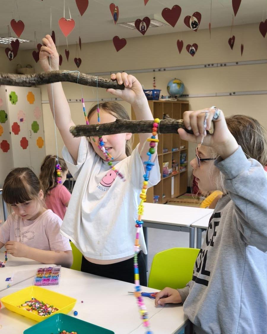 Kinder basteln fantasievolle Windspiele