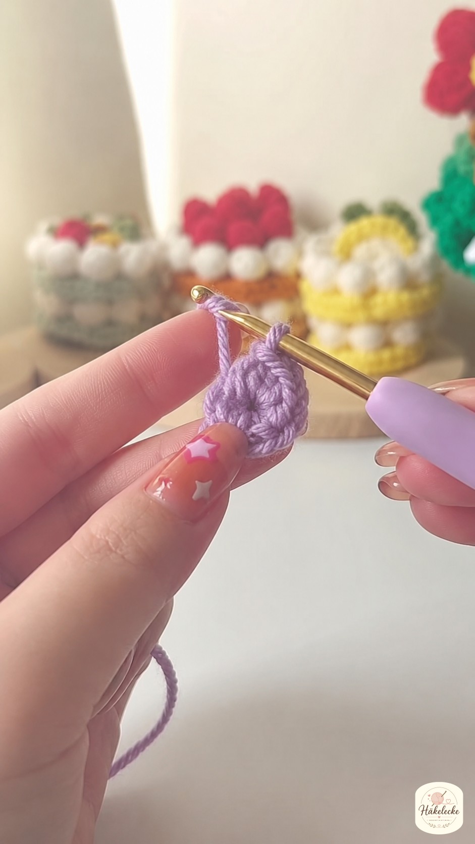Hände legen einen Magischen Ring aus lila Garn als ersten Schritt der Mini Herz häkeln Anleitung