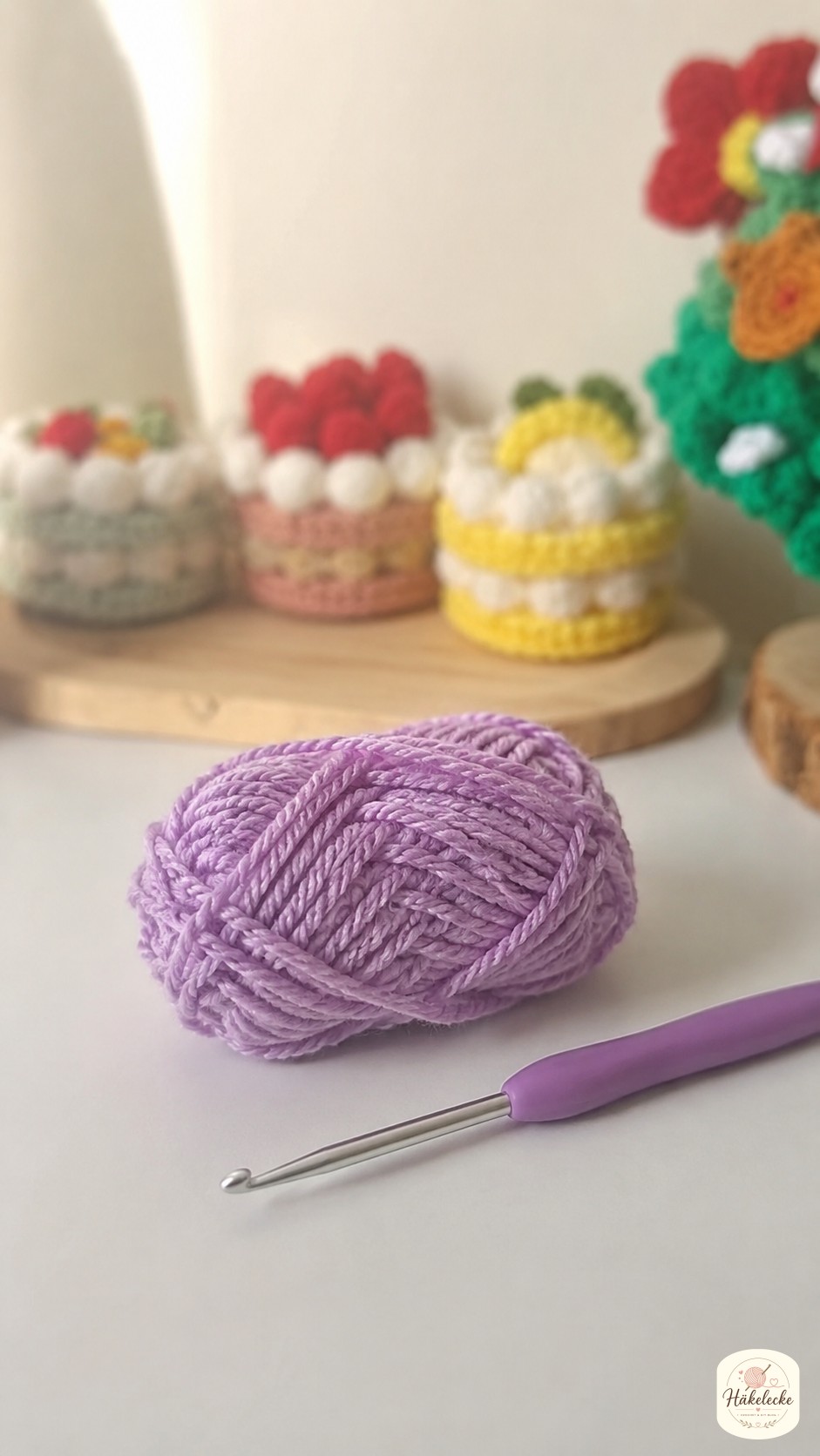 Lavendelfarbenes Garn und Häkelnadel bereit für die Mini Herz häkeln Anleitung auf dem Tisch
