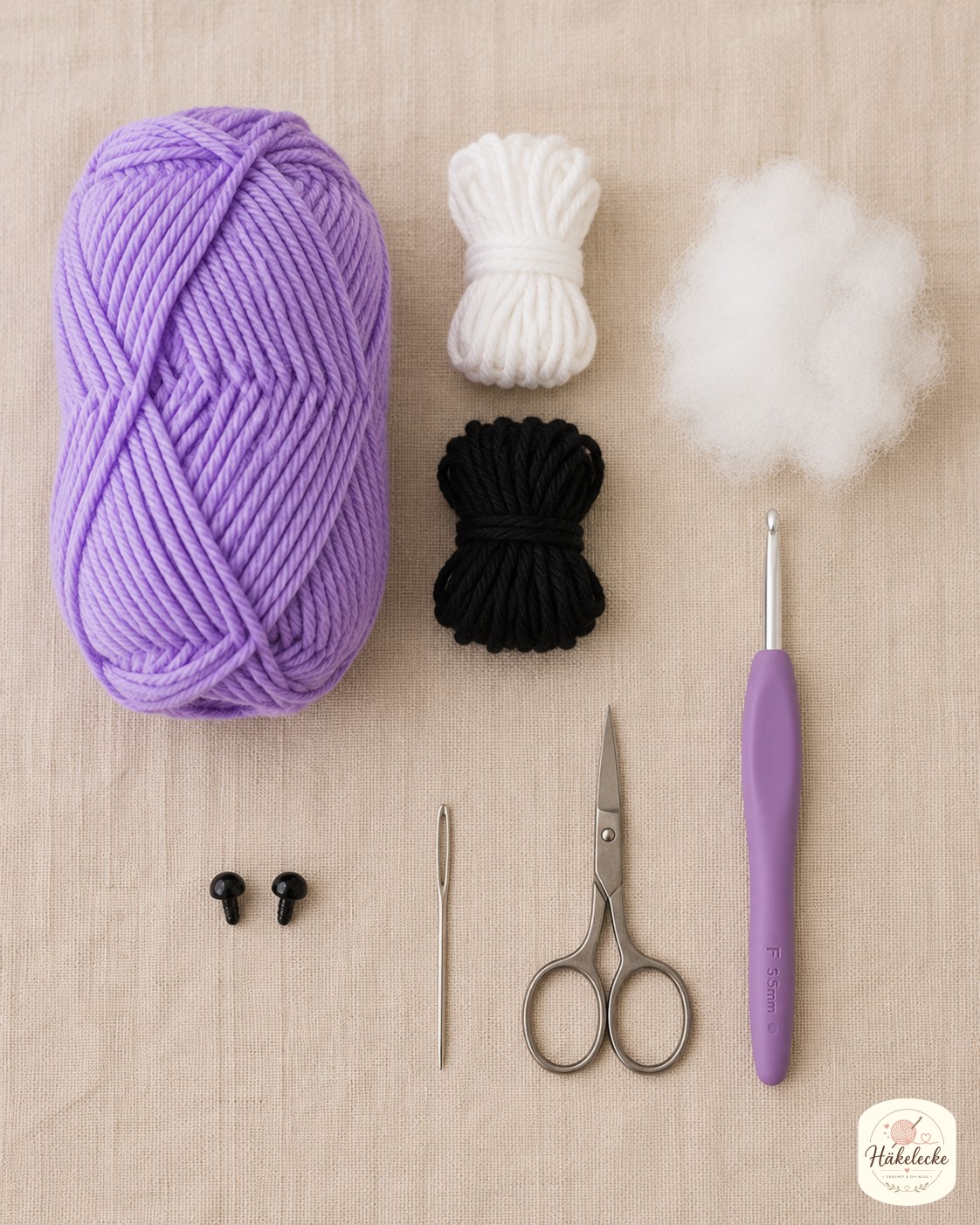 Materialien zum Mini Triceratops Amigurumi häkeln: lavendelfarbenes Garn, Nadel, Sicherheitsaugen und Füllwatte.