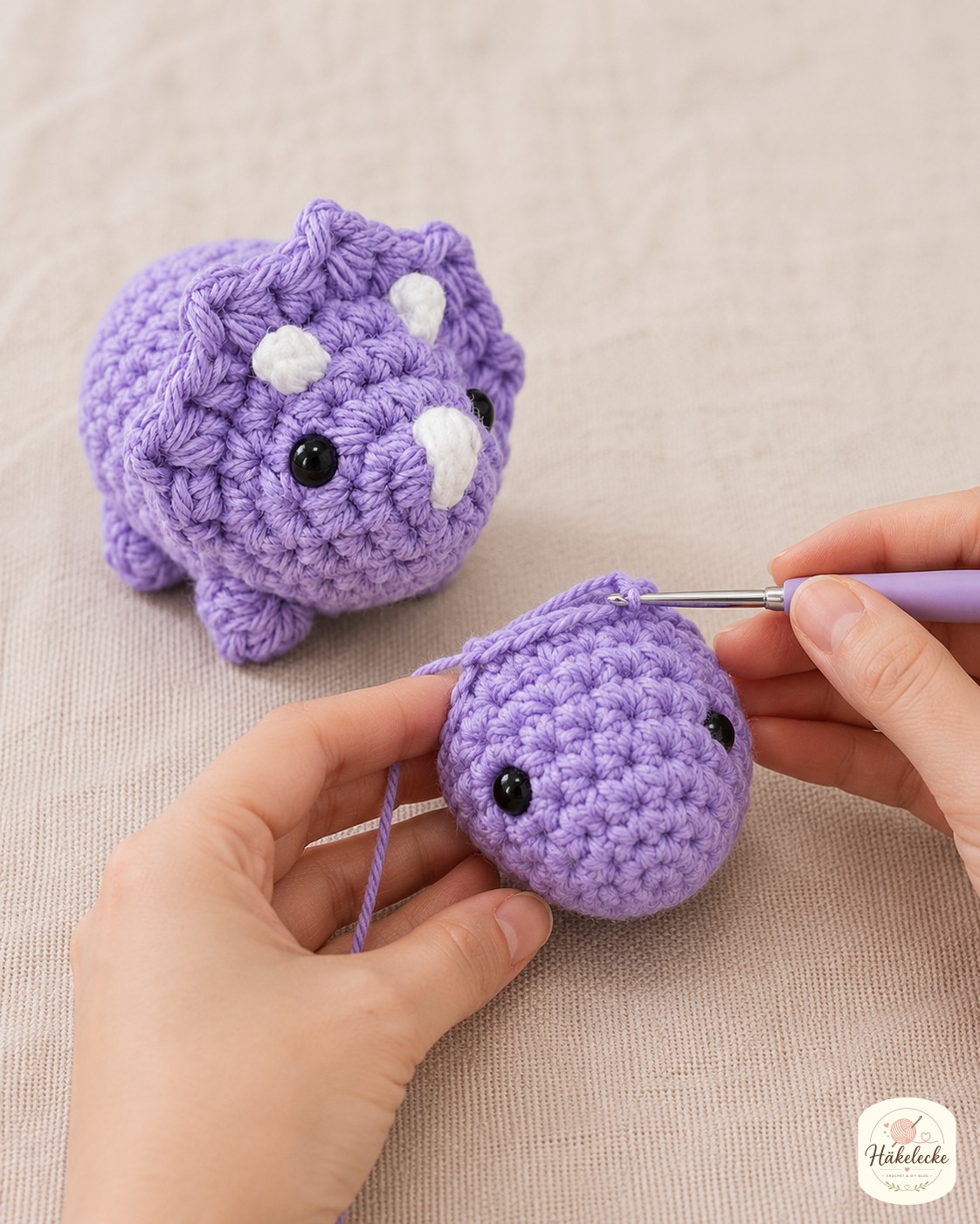 Der Kopf mit kleiner Schnauze entsteht separat neben dem bereits fertig wirkenden Körper des Amigurumi-Dinos.