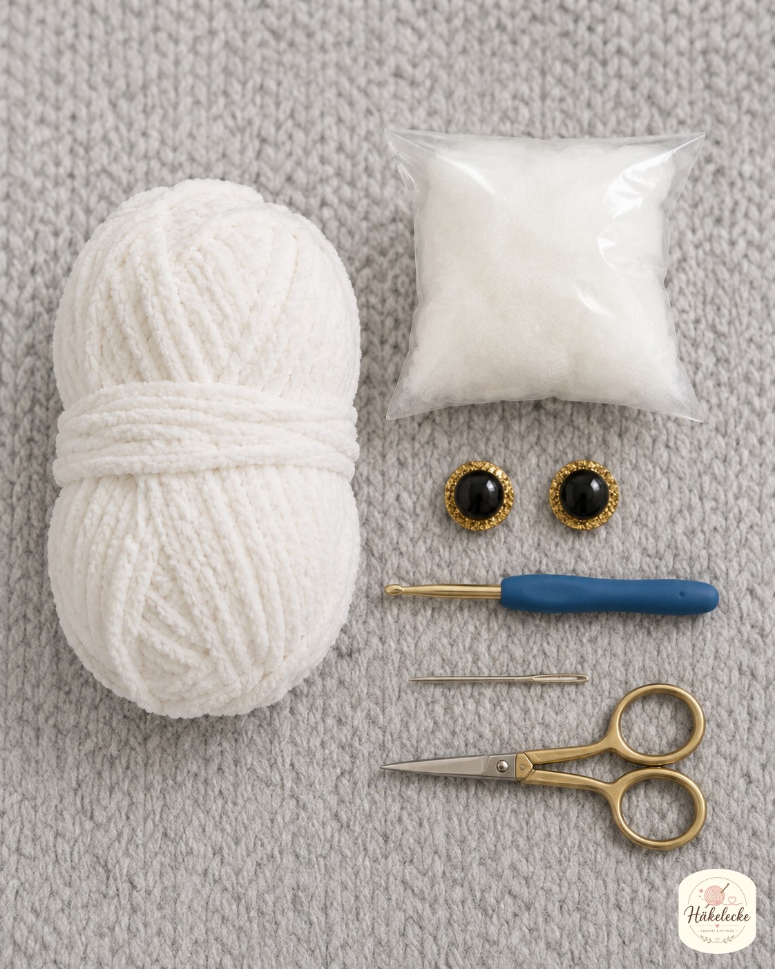 Materialien zum Schneeeule Amigurumi häkeln liegen bereit: Chenille-Garn, Glitzeraugen, Füllwatte und Häkelnadel