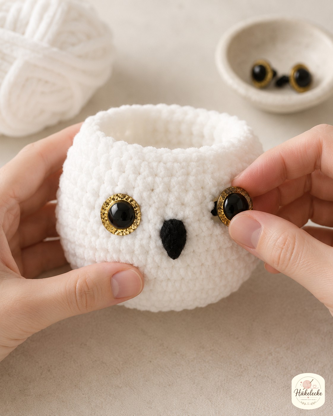 Goldene Glitzer-Sicherheitsaugen werden beim Schneeeule Amigurumi häkeln in den Kopf eingesetzt