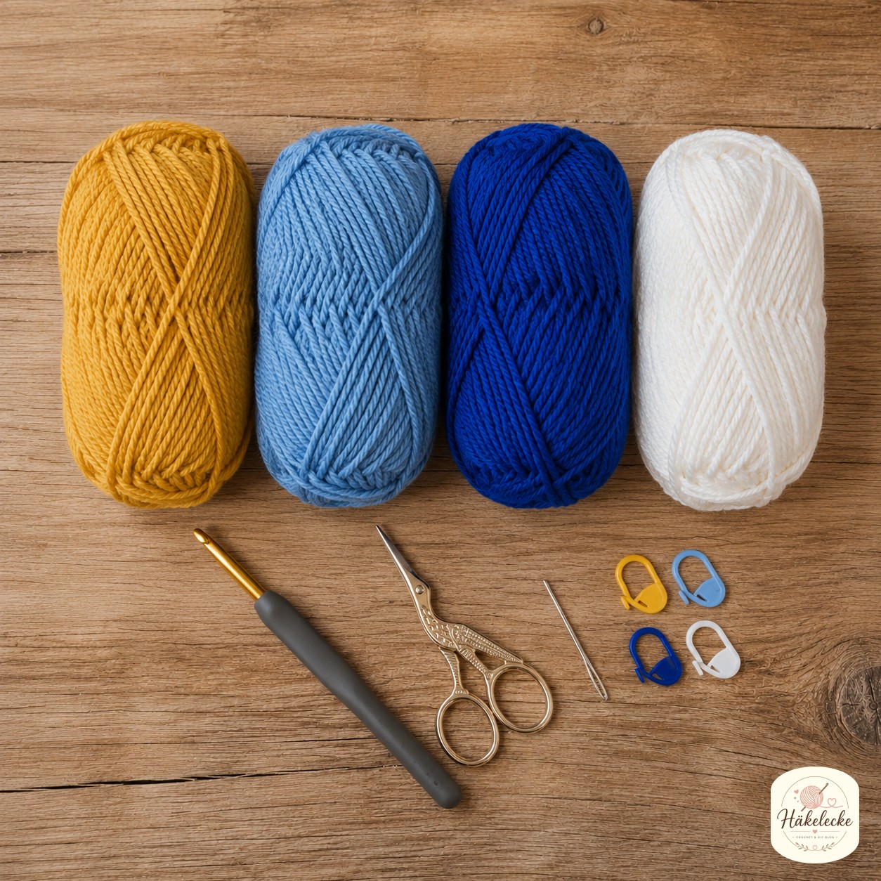 Wolle, Häkelnadel und Zubehör für den Sonne und Mond Granny Square liegen bereit auf dem Holztisch