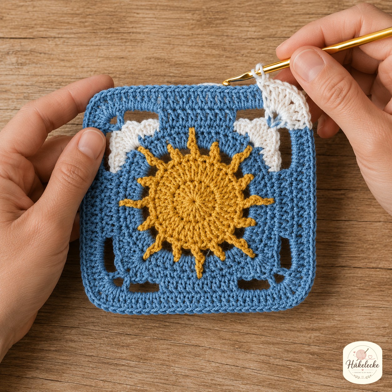 Weiße Wolkenbüschel entstehen in den Ecken des blauen Sonne und Mond Granny Square