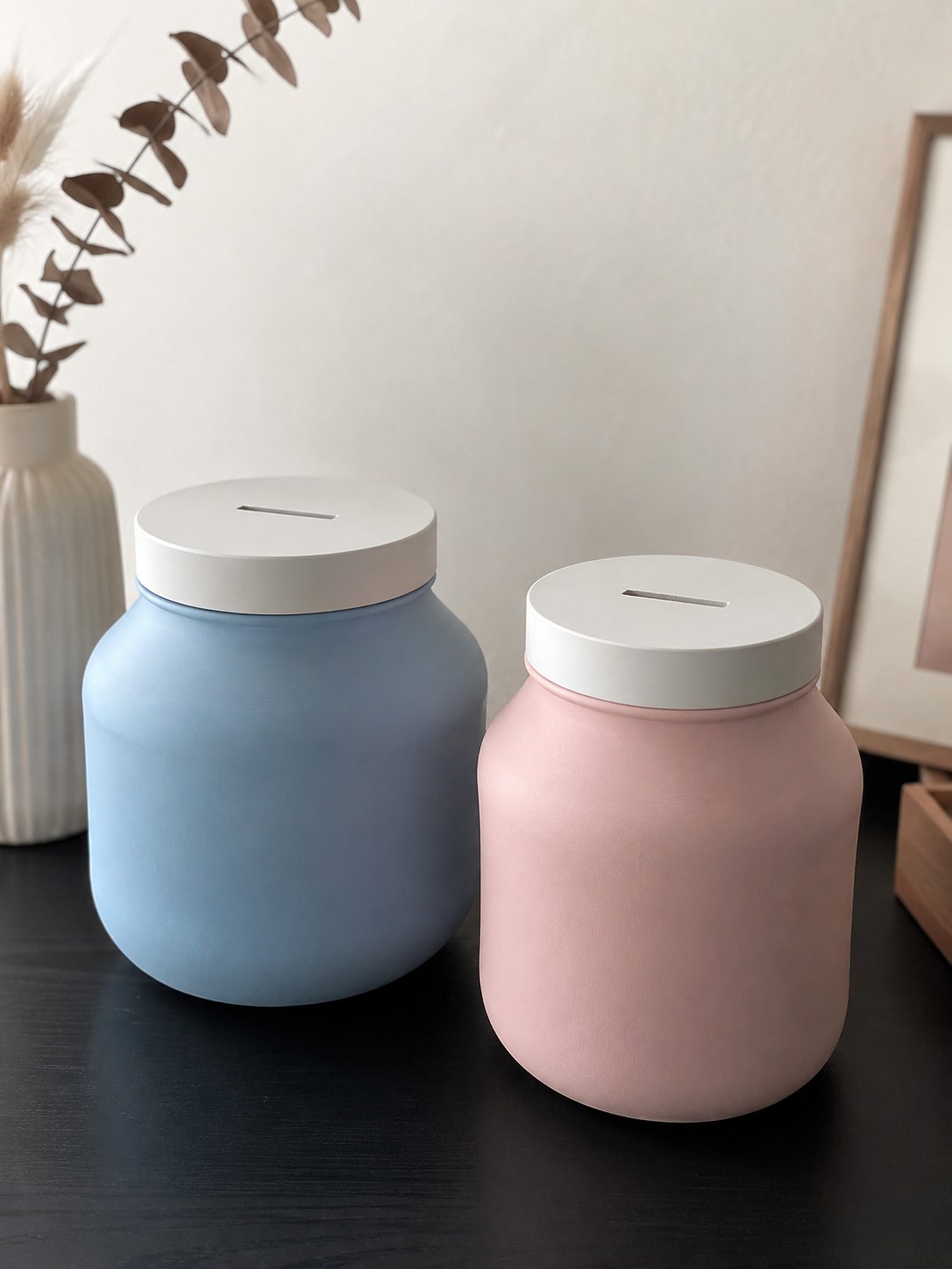 Zwei matte Glasgefäße in Blau und Rosa mit Schlitzdeckel werden zur Spardose, eine schöne Tablettenflaschen Upcycling Idee.
