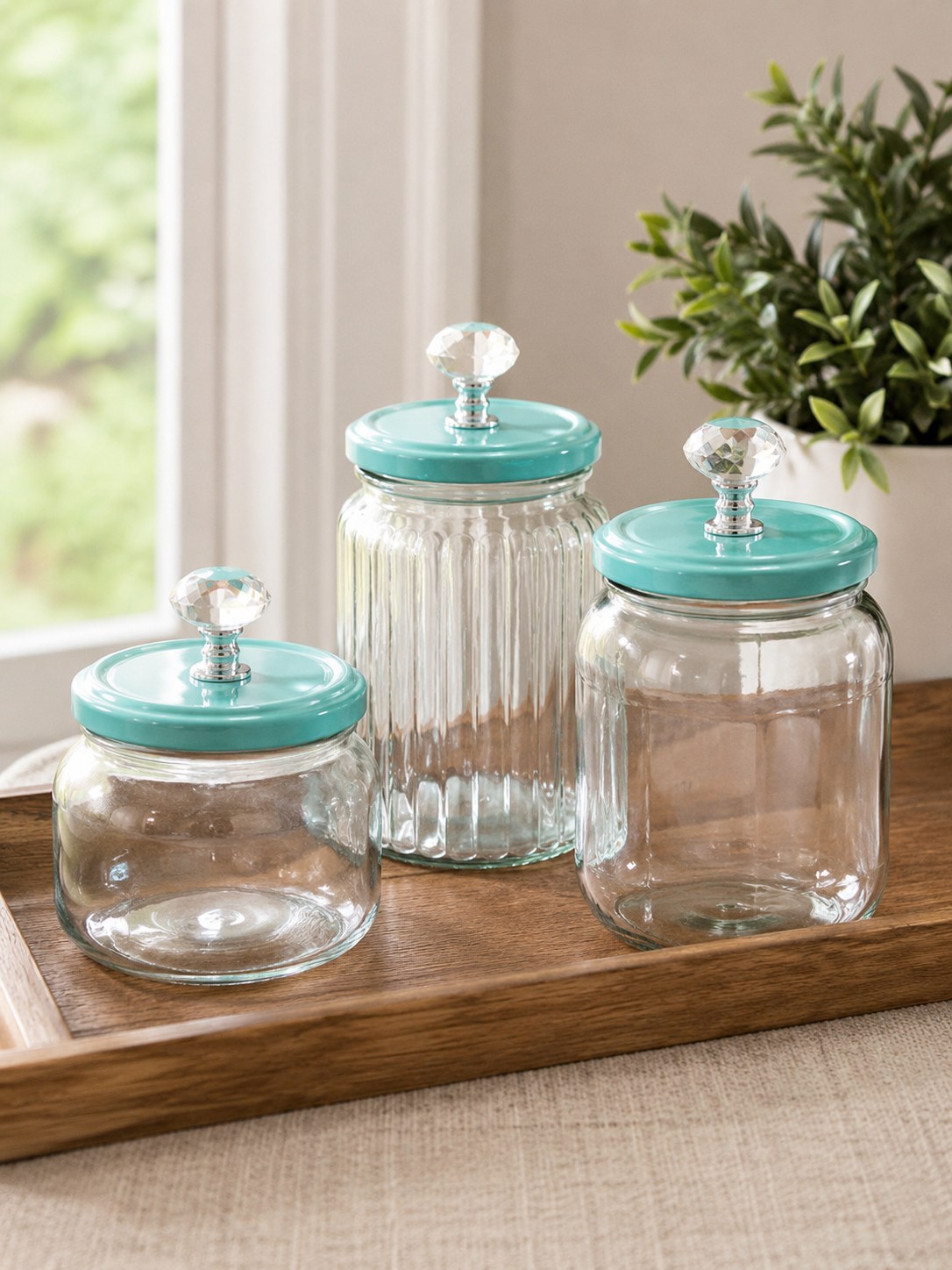 Geriffelte Vorratsgläser mit türkisen Deckeln und Kristallknauf zeigen edles Glas-Upcycling für die Küche.