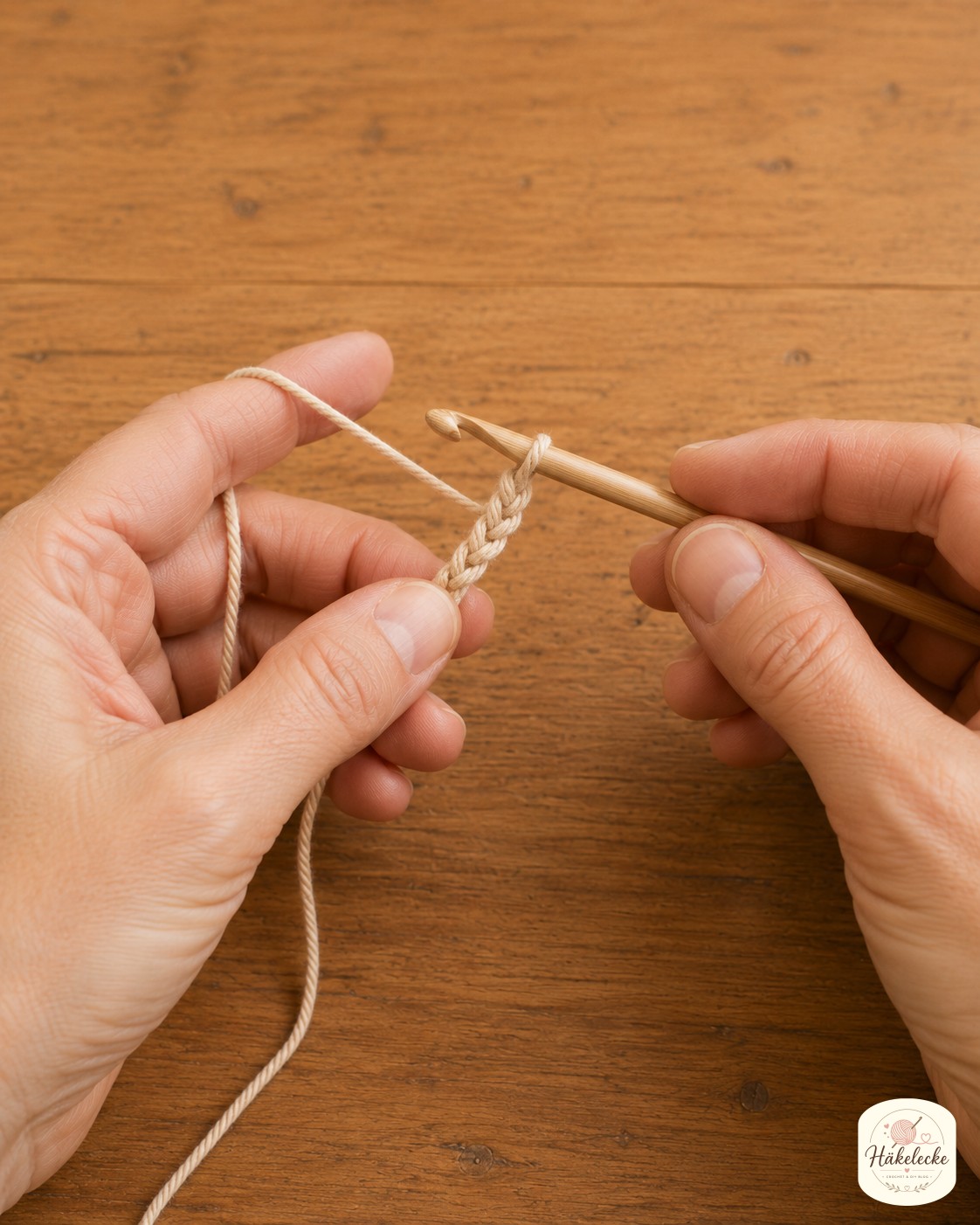 Die Hände beginnen die Anfangsluftmaschenkette in Beige, der erste Schritt beim Topflappen häkeln mit festen Maschen.